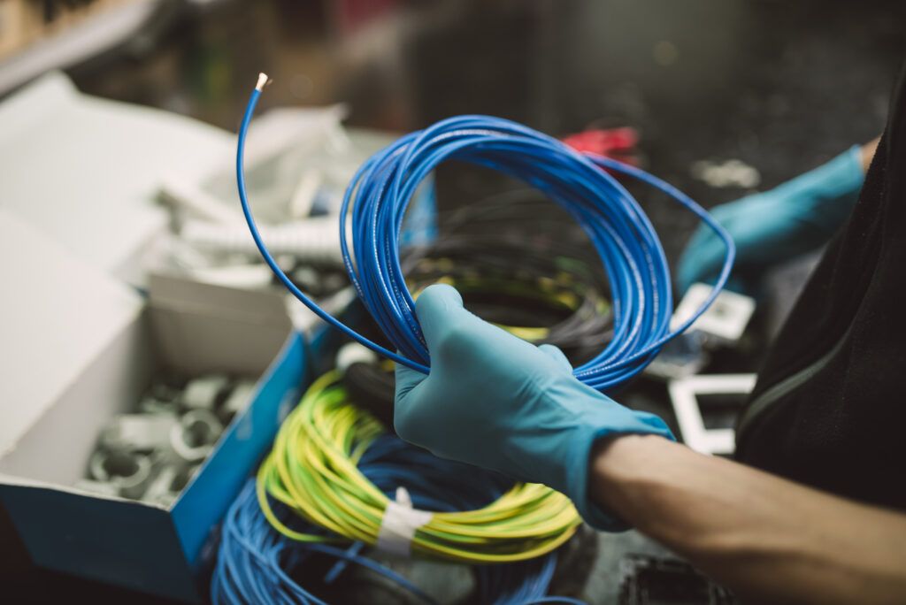 Detalle de un hombre sosteniendo un rollo de cable eléctrico